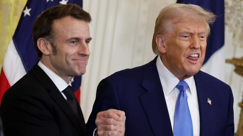 Donald Trump with French prime minister with his tongue touching his teeth.