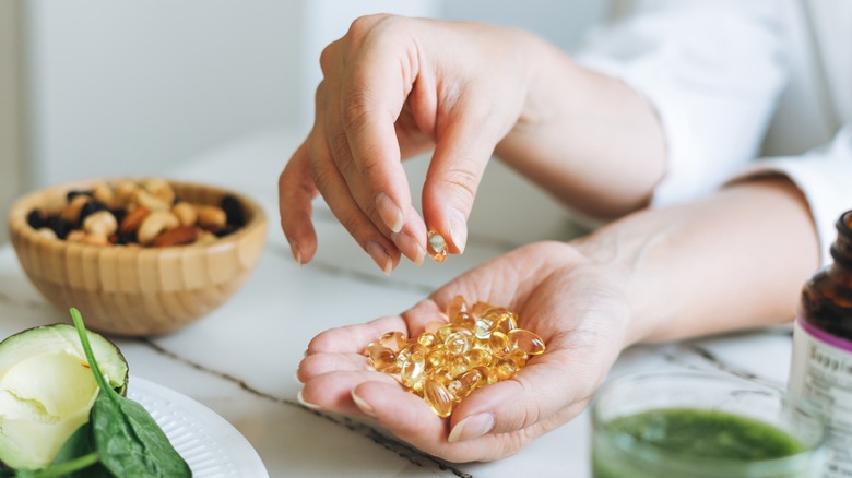 Woman holding vitamin supplements