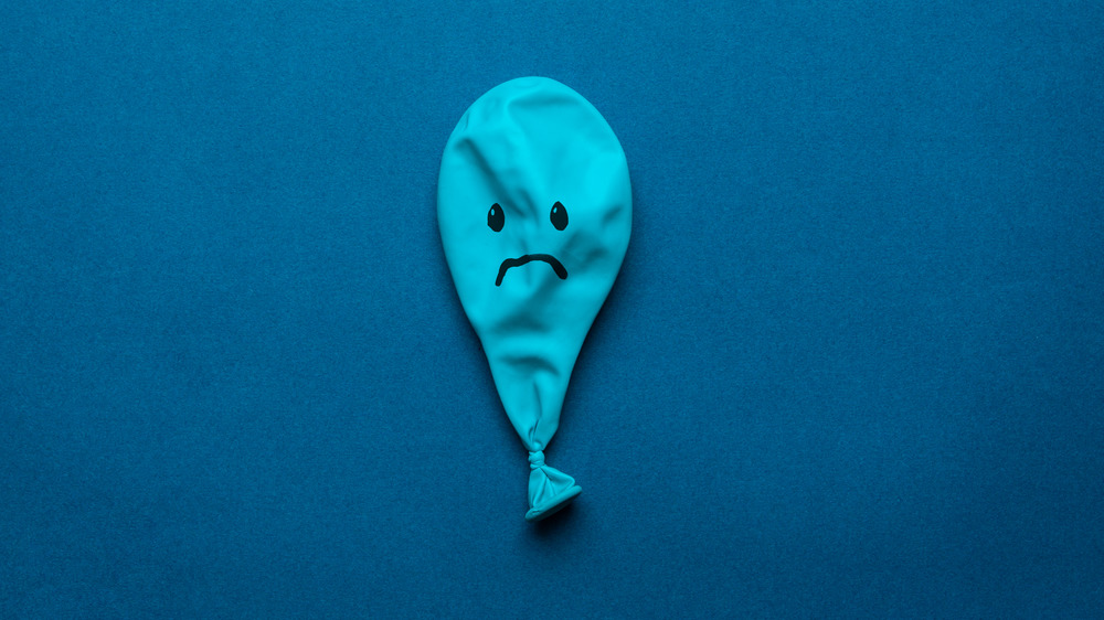 Deflated blue balloon with frown