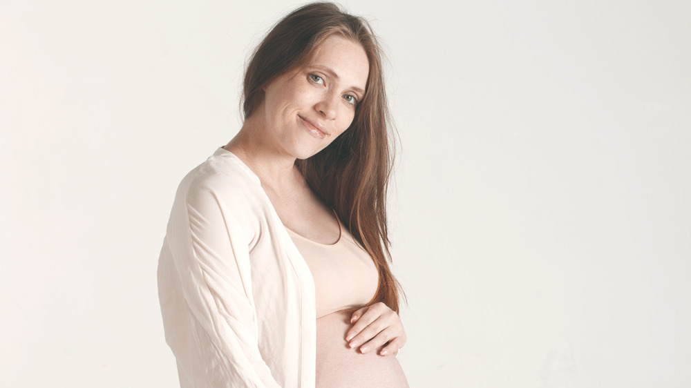 Pregnant woman smiling at the camera