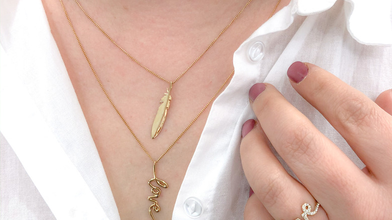 woman wearing dainty gold stackable necklaces