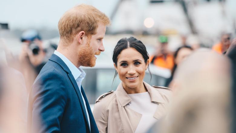 Prince Harry and  Meghan surrounded by paparazzi
