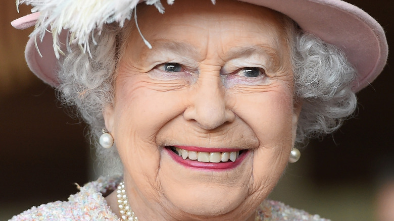 Queen Elizabeth II smiling in pink
