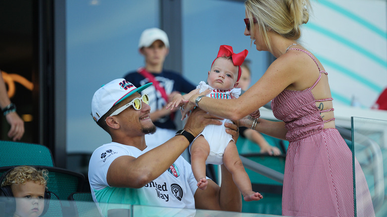 Brittany Mahomes hands her daughter to Patrick Mahomes