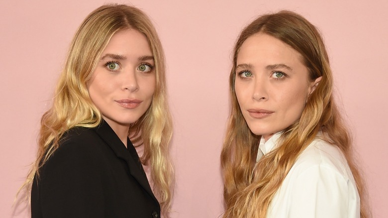 Mary Kate and Ashley Olsen posing