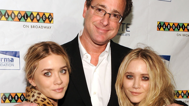 Bob Saget hugging Mary-Kate and Ashley Olsen on red carpet 