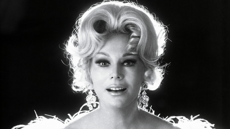 A black-and-white photo of Eva Gabor smiling with her mouth open
