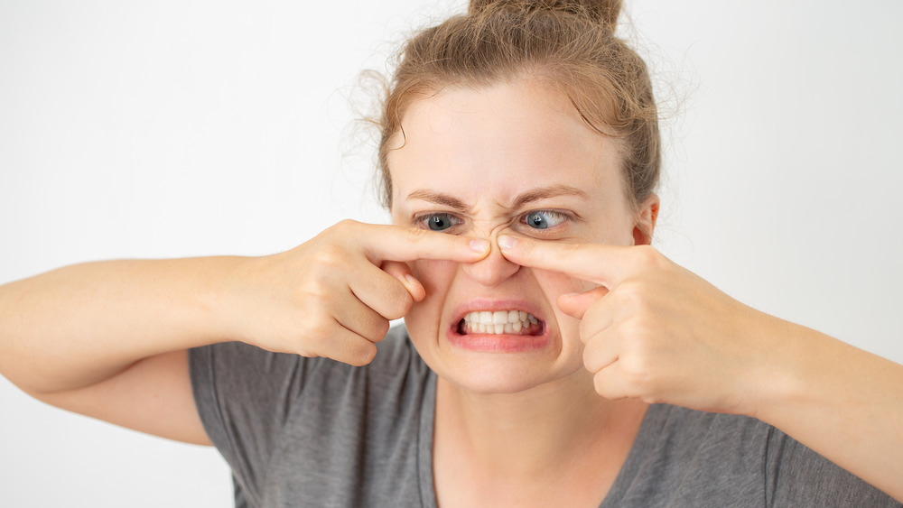 A woman popping a pimple 