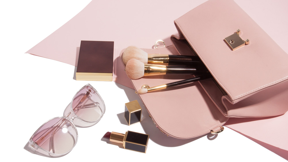 Beauty products spilling out of a purse
