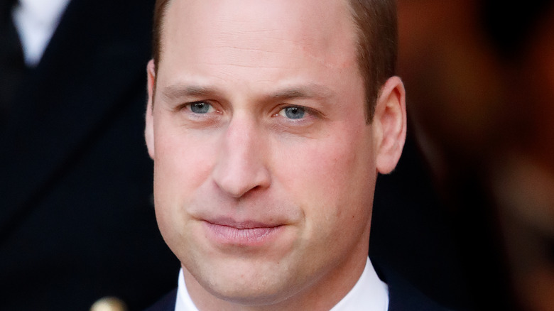 Prince William looks smiles thinly