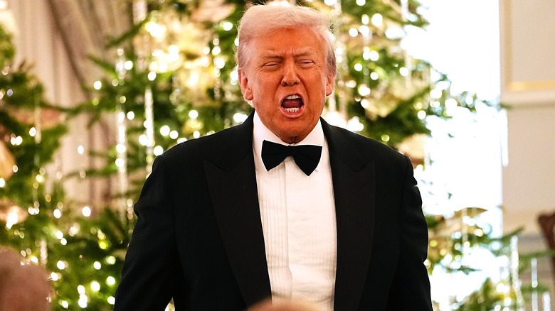 Donald Trump yelling in a tuxedo in front of a Christmas tree