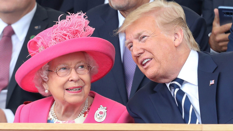 Queen Elizabeth in pink with Donald Trump smiling