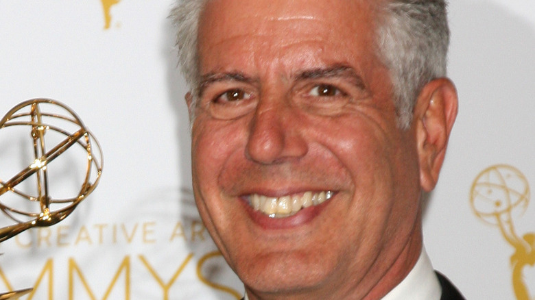 Anthony Bourdain holding a Creative Emmy