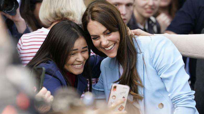 A laughing Princess Catherine taking a selfie with an excited fan