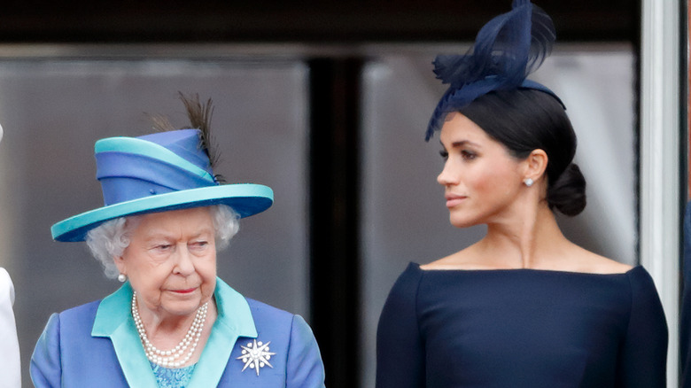 Queen Elizabeth II and Meghan, Duchess of Sussex watch a flypast to mark the centenary of the Royal Air Force from the balcony of Buckingham Palace in London, England (2018)