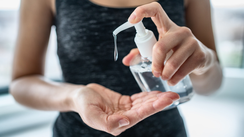 Woman putting on hand sanitizer