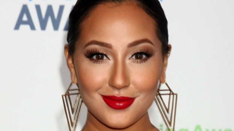 Adrienne Bailon smiling at a public event