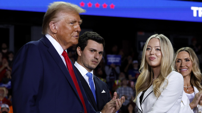 Tiffany Trump and Michael Boulos smiling with Donald Trump