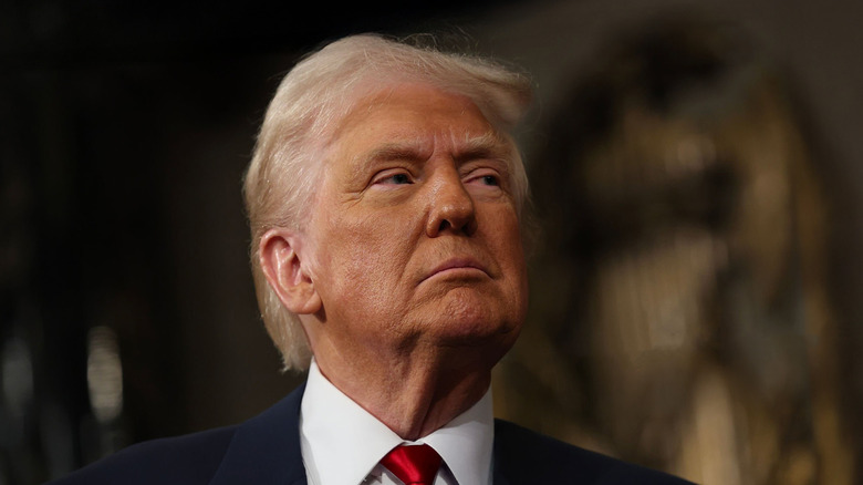 Donald Trump posing in a suit and red tie in the U.S. Capitol.