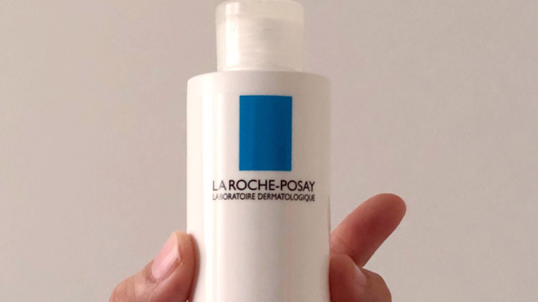 Woman holding a bottle of Laroche-Posay lotion
