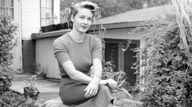 Vera Miles posing at home sitting in her garden.