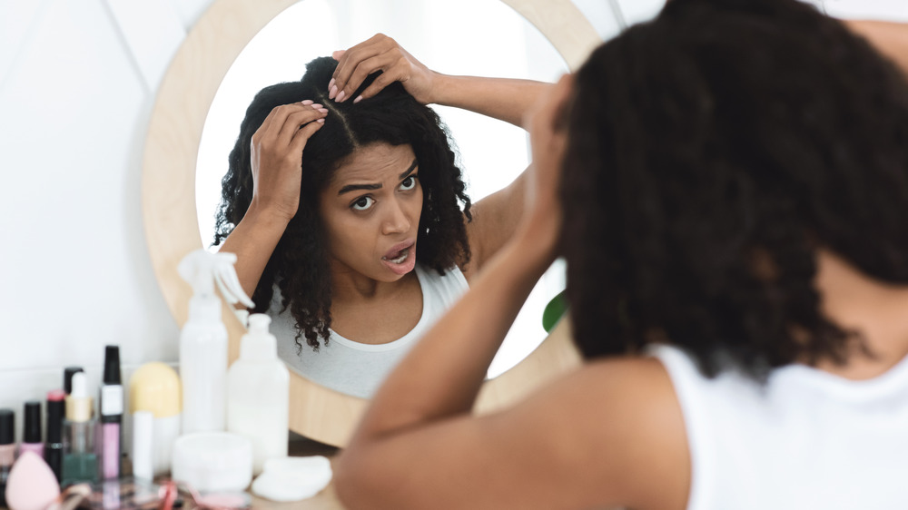 Woman examining hair for signs of loss