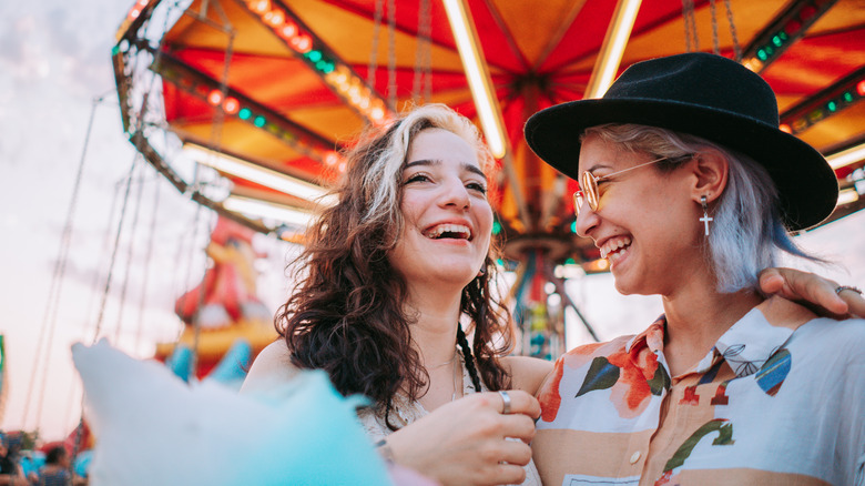 A couple embraces by carousel