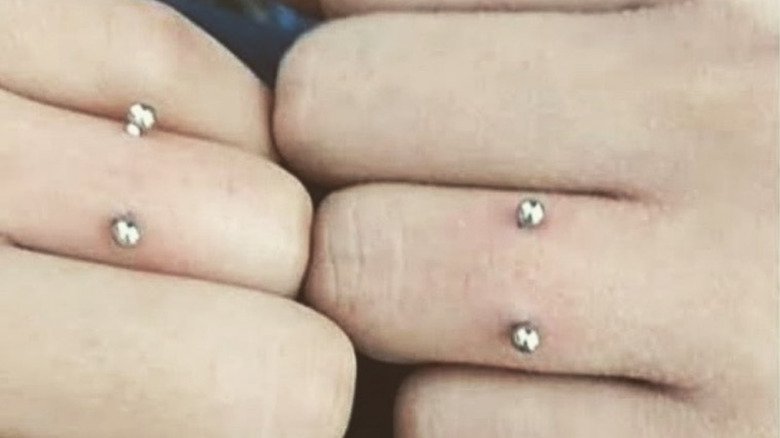 Matching wedding ring finger dermal piercings