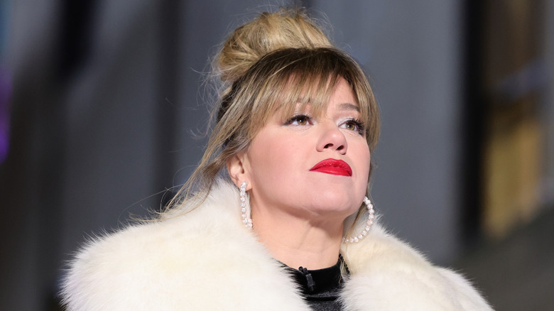 A closeup of Kelly Clarkson in a white furry coat
