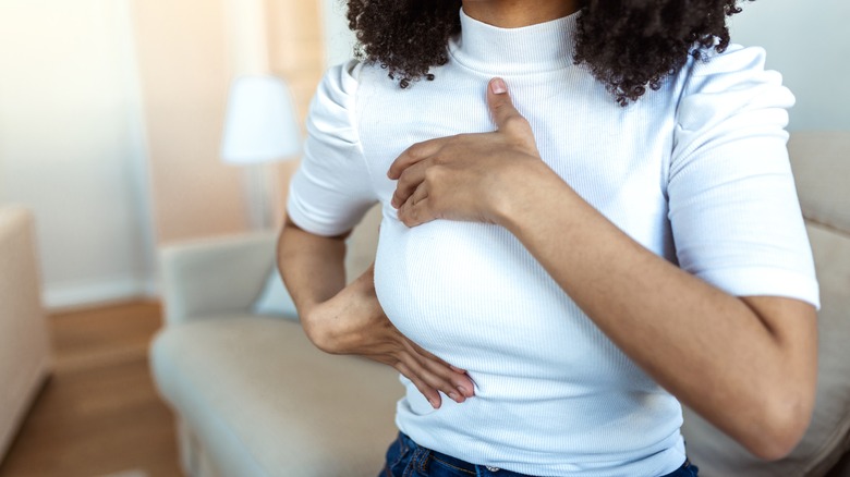 A woman performing a breast self exam