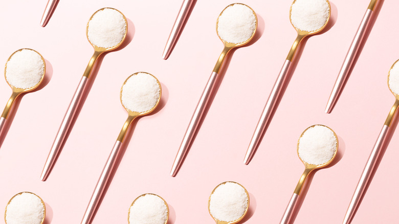 Skincare spoons on a pink background 