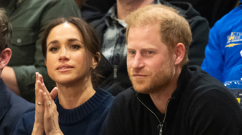 Meghan Markle and Prince Harry looking uneasy.