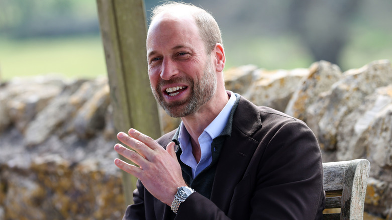 Prince William laughing while sitting outside