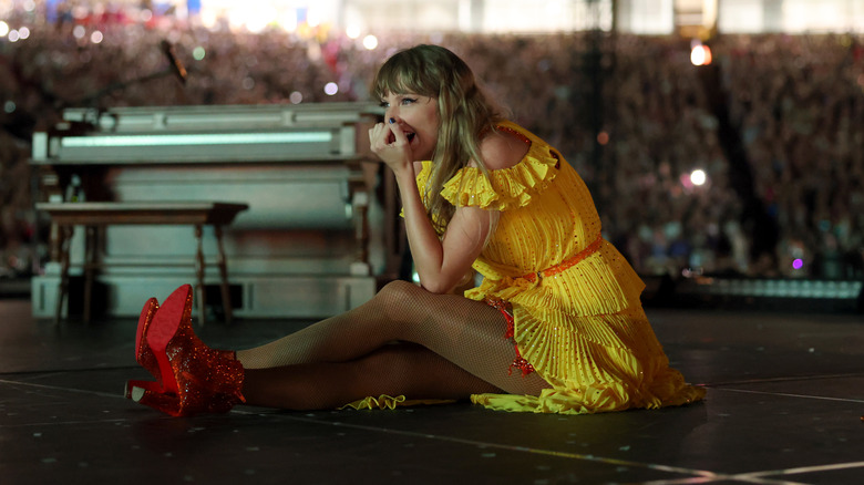 Taylor Swift sitting on stage during Eras tour