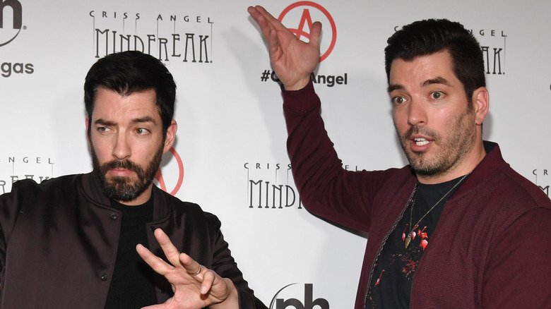 Drew and Jonathan Scott pose together looking surprised