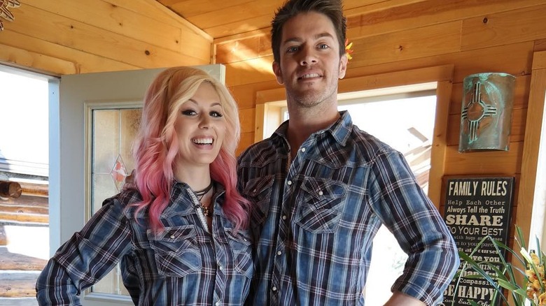 J.D. Scott smiles next to his wife in matching plaid shirts