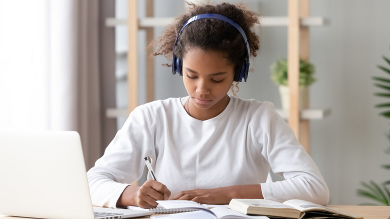 Child studying listening to music