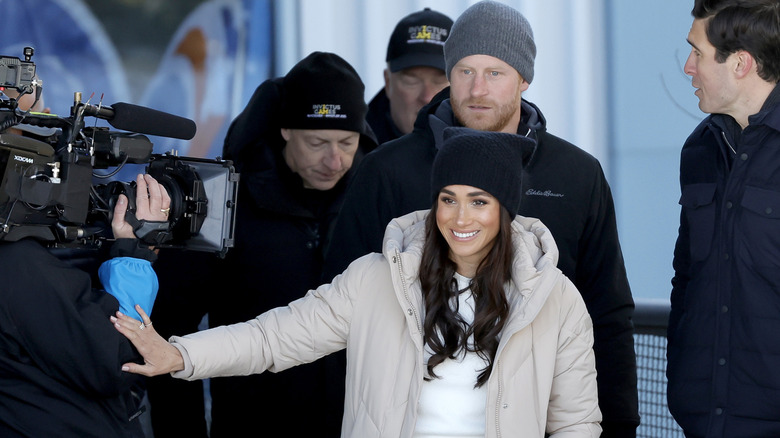 Meghan Markle and Prince Harry walking past photographers