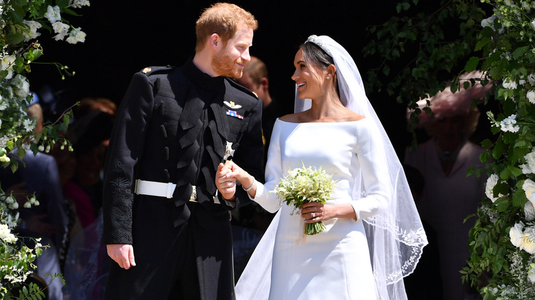 Prince Harry and Meghan Markle smiling at each other on their wedding day
