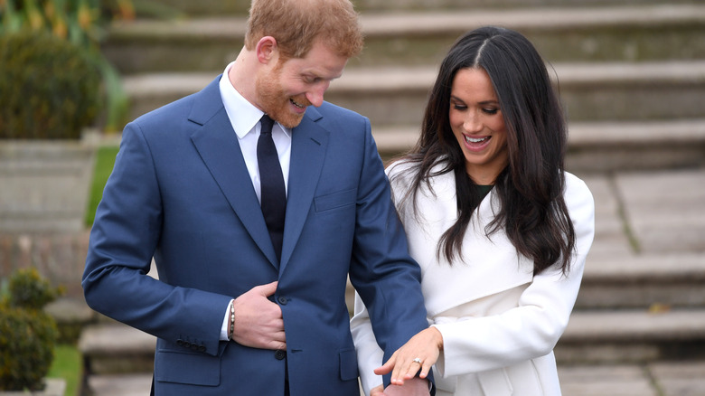 Meghan Markle and Prince Harry admiring her engagement ring during their engagement photo call