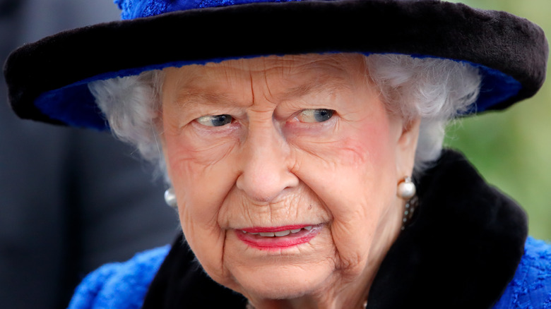 Queen Elizabeth II wears Royal Blue coat and hat trimmed in black.