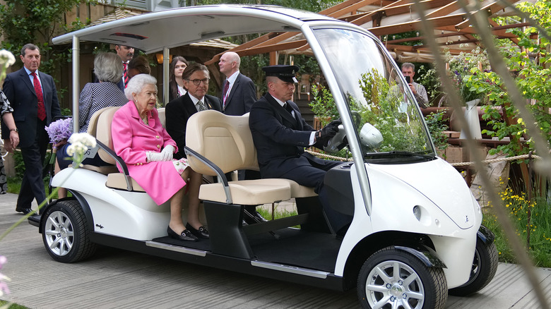 Queen Elizabeth riding in a golf cart