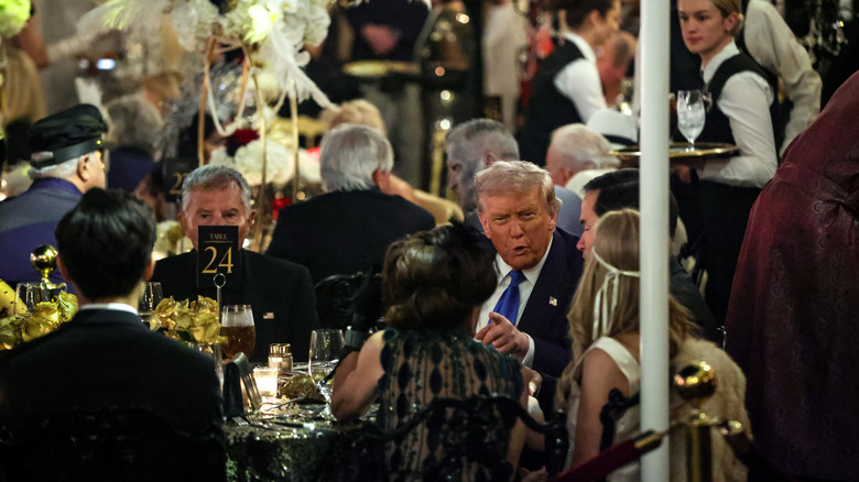 Donald Trump among a crowd of people dressed in costume.