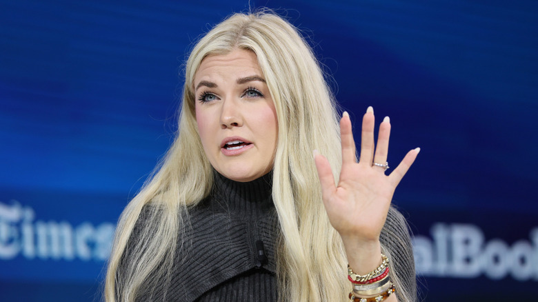 Erika Kirk speaking at an event and raising her hand