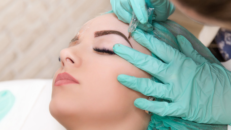 Woman getting her eyebrows tinted by a professional