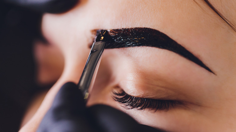 Woman getting henna eyebrows