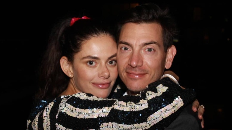 Karly Snow smiles with her arms wrapped around her smiling husband actor Matty Finochio