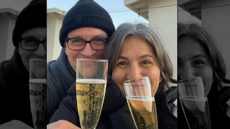 Tom Everett Scott and wife Jenni Galllagher holding champagne flutes in a selfie