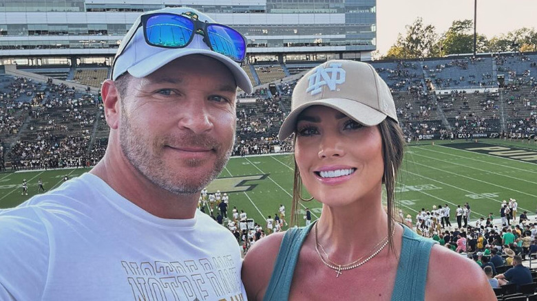 Brian Urlacher and Jennipher Frost in front of a football field