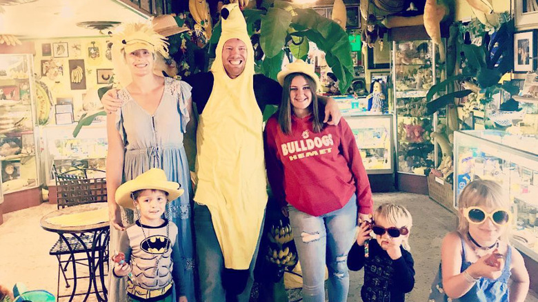 McKey Sullivan wearing a hat and standing next to her husband, Sam Alvey, in a banana suit, and their kids